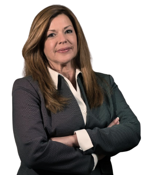 A woman with long brown hair, wearing a gray blazer and white collared shirt, stands with arms crossed and a confident expression, embodying professionalism in revenue cycle management.