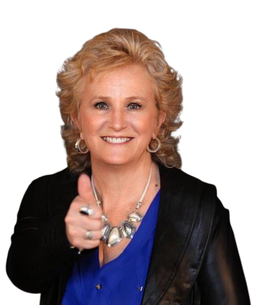 Smiling woman with curly blonde hair, wearing a blue shirt, black jacket, silver necklace, and hoop earrings, giving a thumbs up gesture—perfect for illustrating success in revenue cycle management.