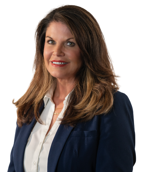 A consultant with long brown hair, wearing a navy blazer over a white blouse, smiles at the camera against a plain background.