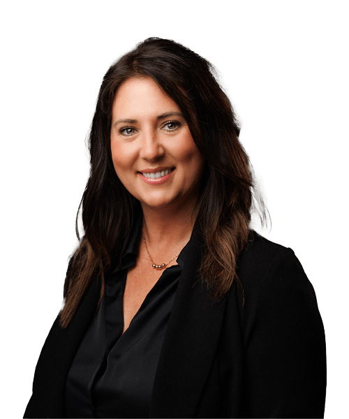 Woman with long, dark, wavy hair wearing a black blazer and blouse, smiling confidently at the camera against a plain white background—a professional consultant ready to assist.